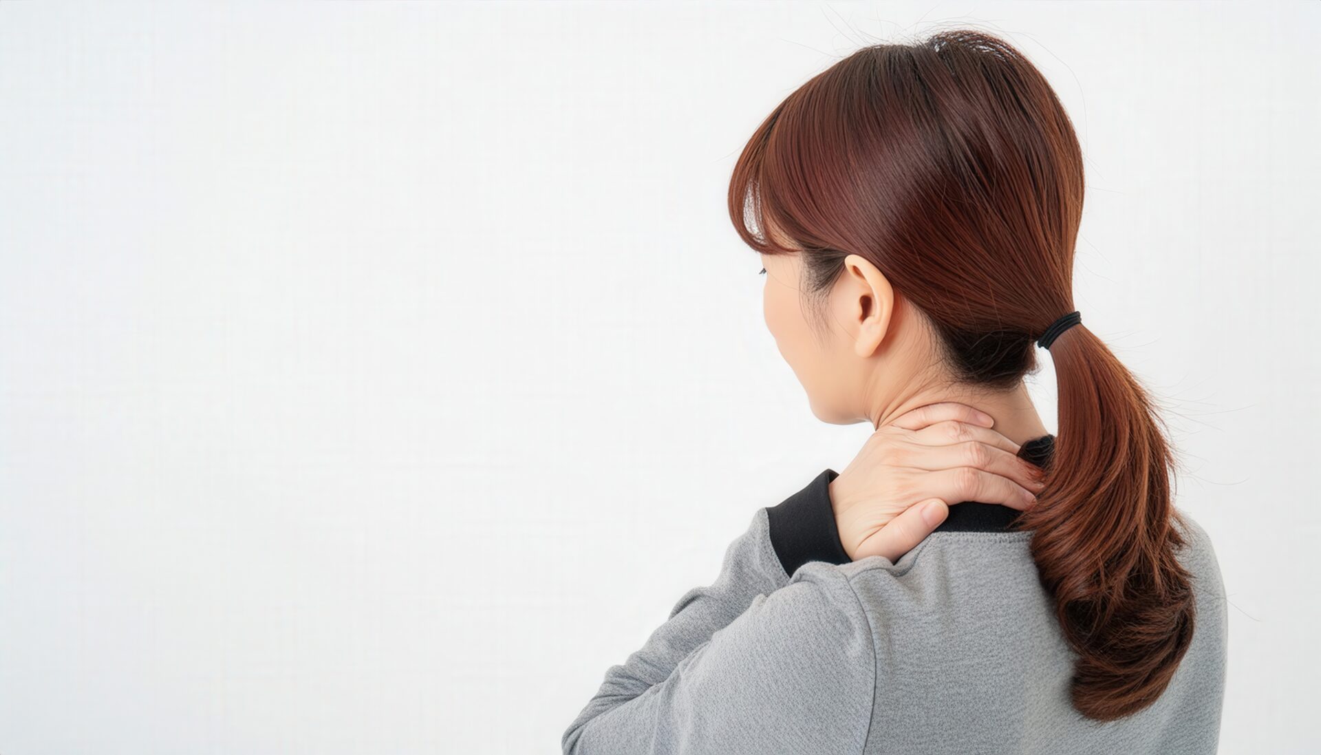 首を押さえる女性の後ろ姿1