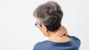 首を押さえる高齢女性の後ろ姿