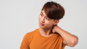 首を押さえる若い男性1