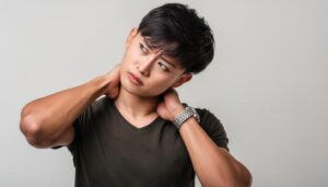 両手で首を押さえる若い男性