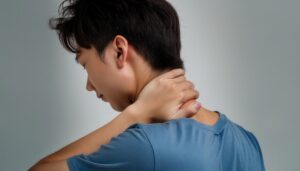 首を押さえる若い男性後ろ姿