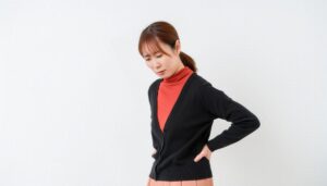 腰を押さえる女性の横顔
