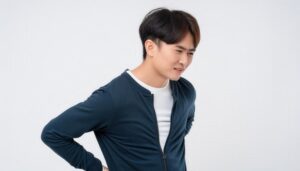 腰の痛みをこらえる男性