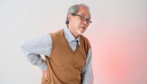 腰の痛みに悩む高齢男性