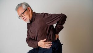 腰に手を当てた高齢男性