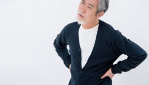 腰の違和感に苦しむ高齢男性