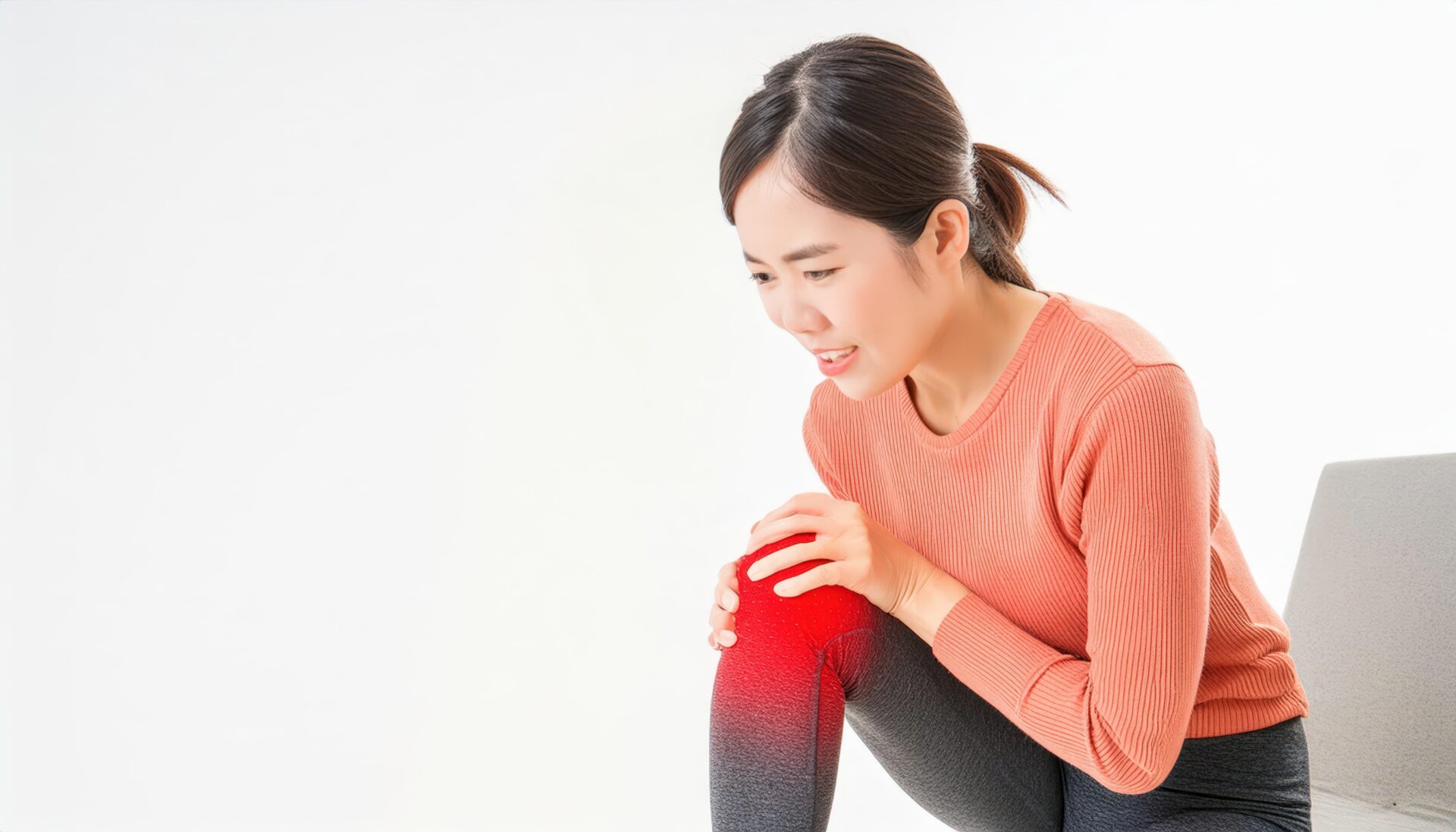 膝を押さえて痛みに耐える女性