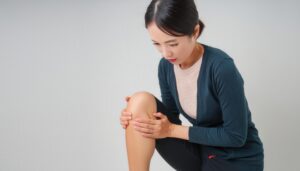 膝に痛みを感じる女性