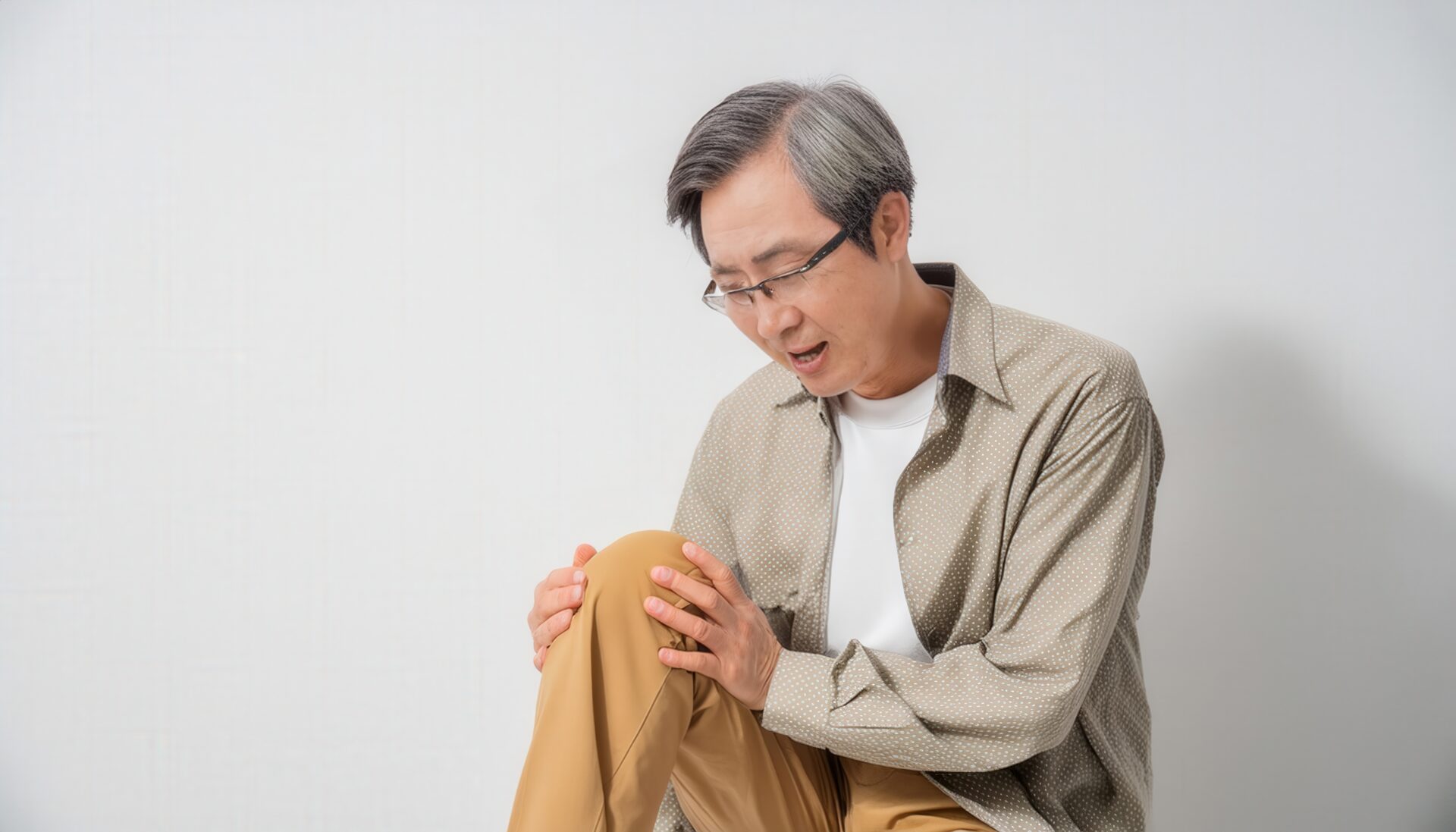 膝を押さえる高齢男性