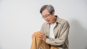膝を押さえる高齢男性
