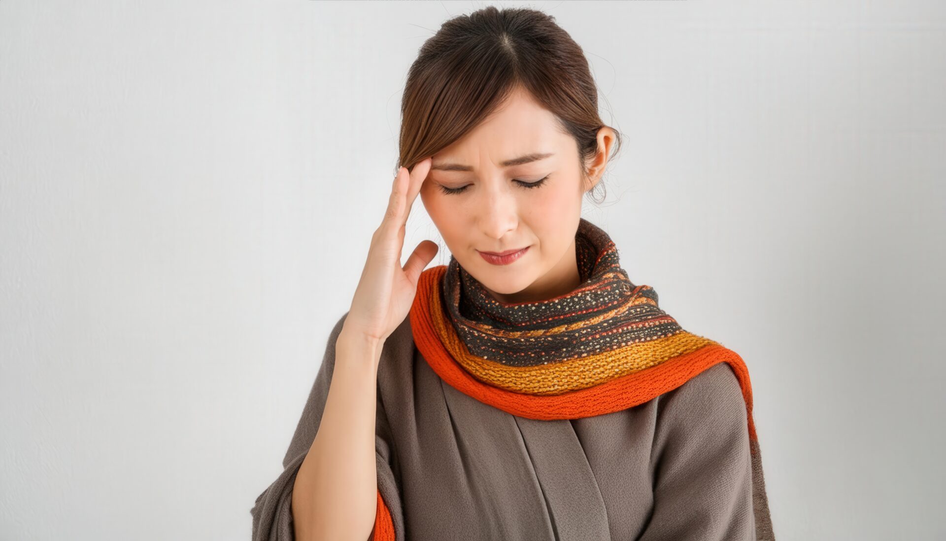 頭痛に苦しむ秋冬の服装の女性