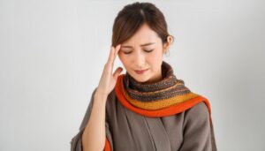 頭痛に苦しむ秋冬の服装の女性