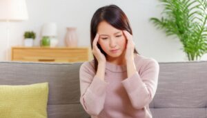 リビングで頭痛に悩む女性