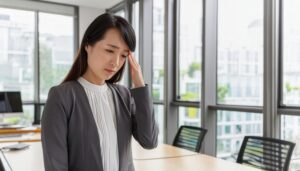 会議室で頭痛を感じる女性