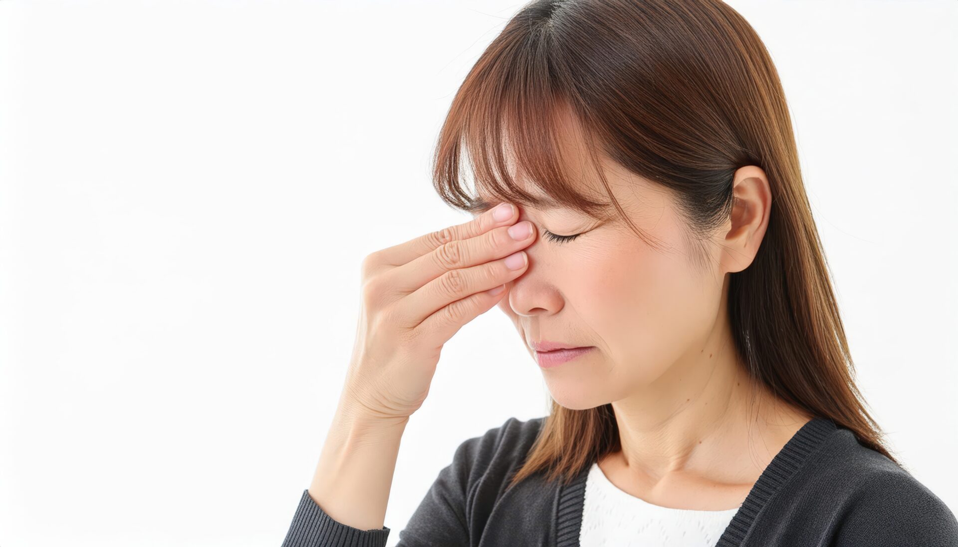 目の疲れで目を押さえる人(1)