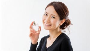 黒いVネック服の女性が香水を手に笑顔