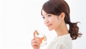 視線を外して香水を持つ白ブラウスの女性