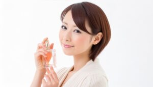 短い茶髪の女性が香水を手に穏やかに微笑む