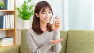 香水のボトルを持つ若い女性