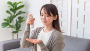 スプレー香水を手のひらに吹きかける女性