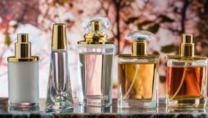 桜の花を背景に並ぶ5本の香水ボトル