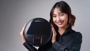 グレー背景でロボット掃除機を持つビジネスパーソン