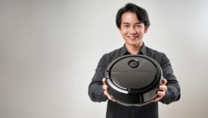 グレー背景でロボット掃除機を掲げるビジネスパーソン