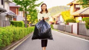 住宅街でゴミ袋を持つ笑顔の若い女性