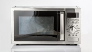 鏡面の台に置かれたシルバーの電子レンジ