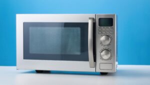 青い背景に置かれたシルバーの電子レンジ