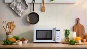 木製カウンターに置かれた白い電子レンジと食材