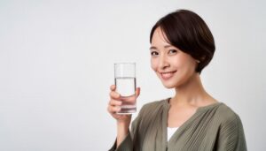 グラスの水を手に持ち微笑む人