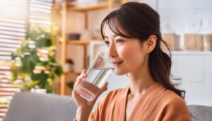 ソファでグラスの水を飲む人
