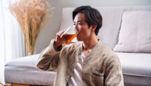 カジュアルな服装でお茶を飲む若い人