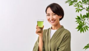 白背景で緑色の飲み物を手に持つ若い人
