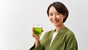 白背景で緑色の飲み物を持つ若い人