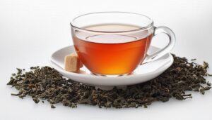 茶葉とシュガーキューブが添えられた透明カップの茶色い飲み物