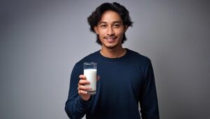 グレー背景で牛乳を持つ若い男性