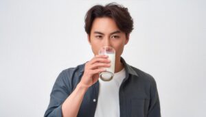 白背景で牛乳を飲む若い男性