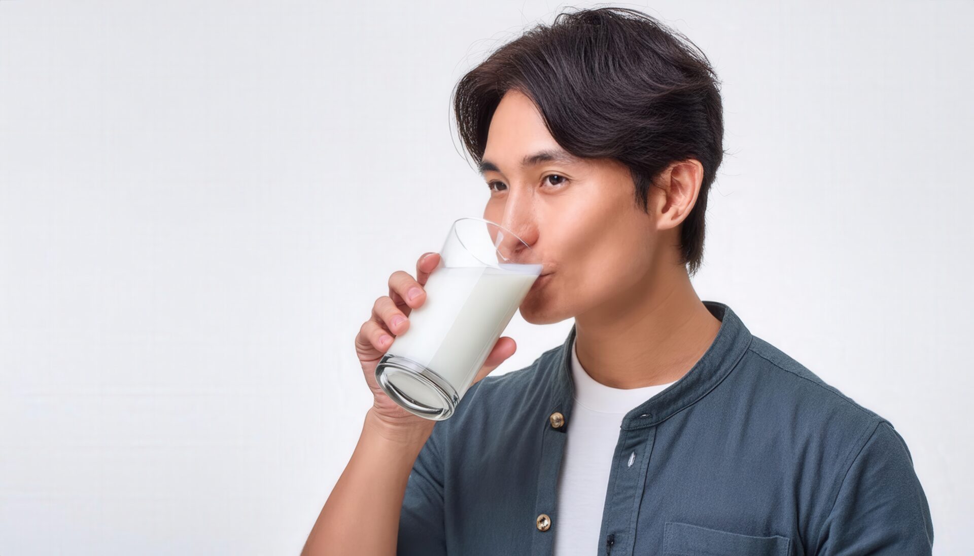 白背景で牛乳を飲む若い男性