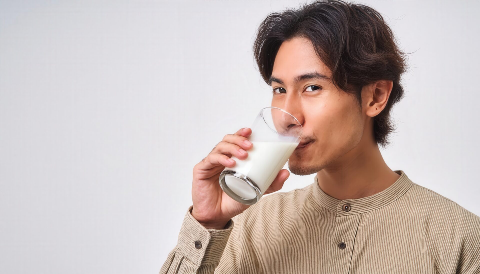 白背景で牛乳を飲む若い男性
