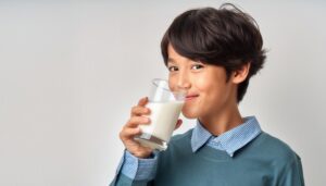 白背景で牛乳を飲む男の子