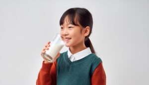 白背景で牛乳を飲む女の子（横向き）