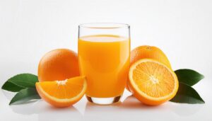 白背景でオレンジジュースと葉付きオレンジ