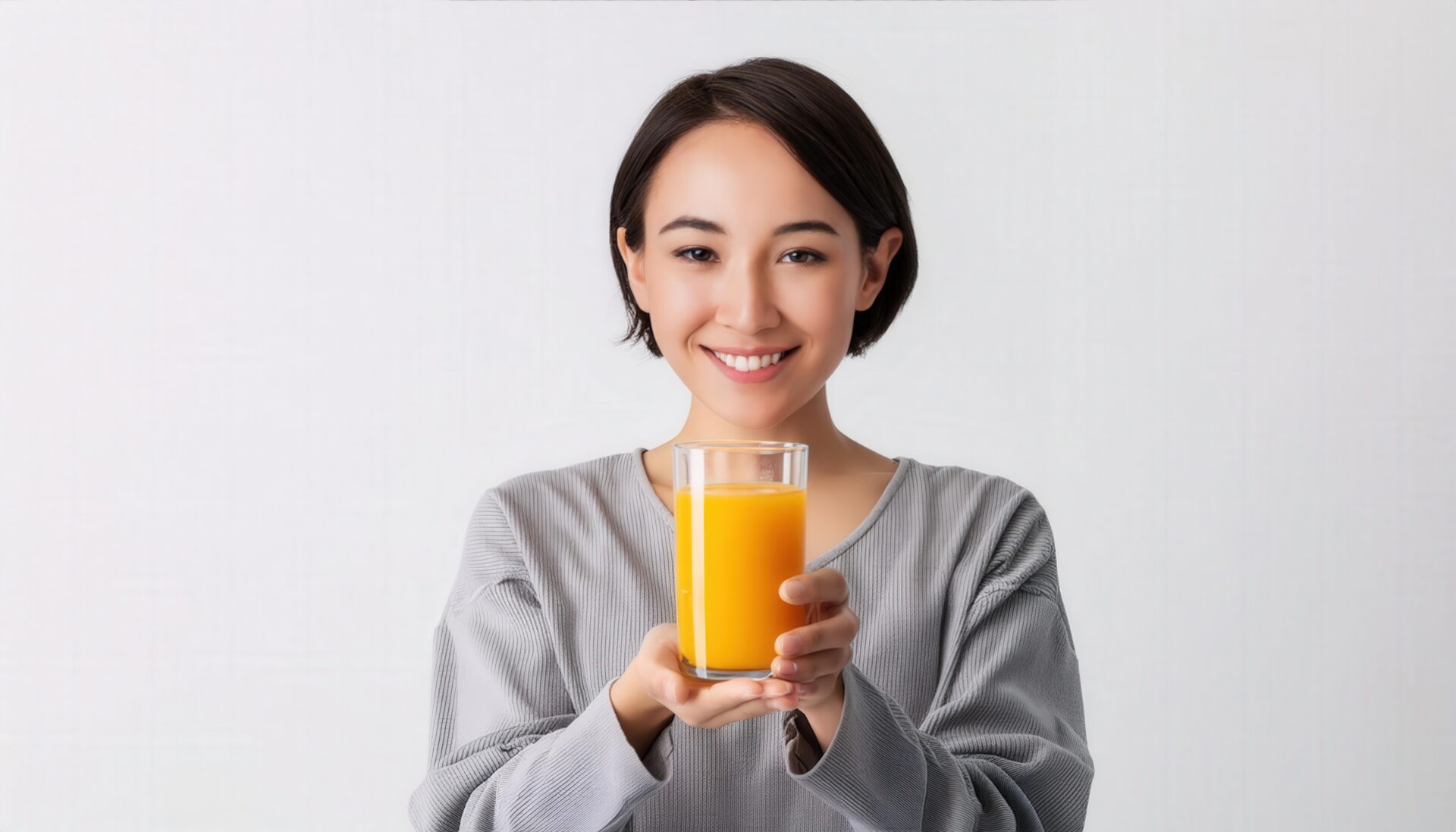 白背景でオレンジジュースを手にする大人