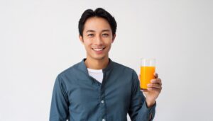 白背景でオレンジジュースを持つ大人