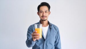 白背景でオレンジジュースを差し出す大人