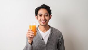 白背景でオレンジジュースを手に持つ笑顔の男性