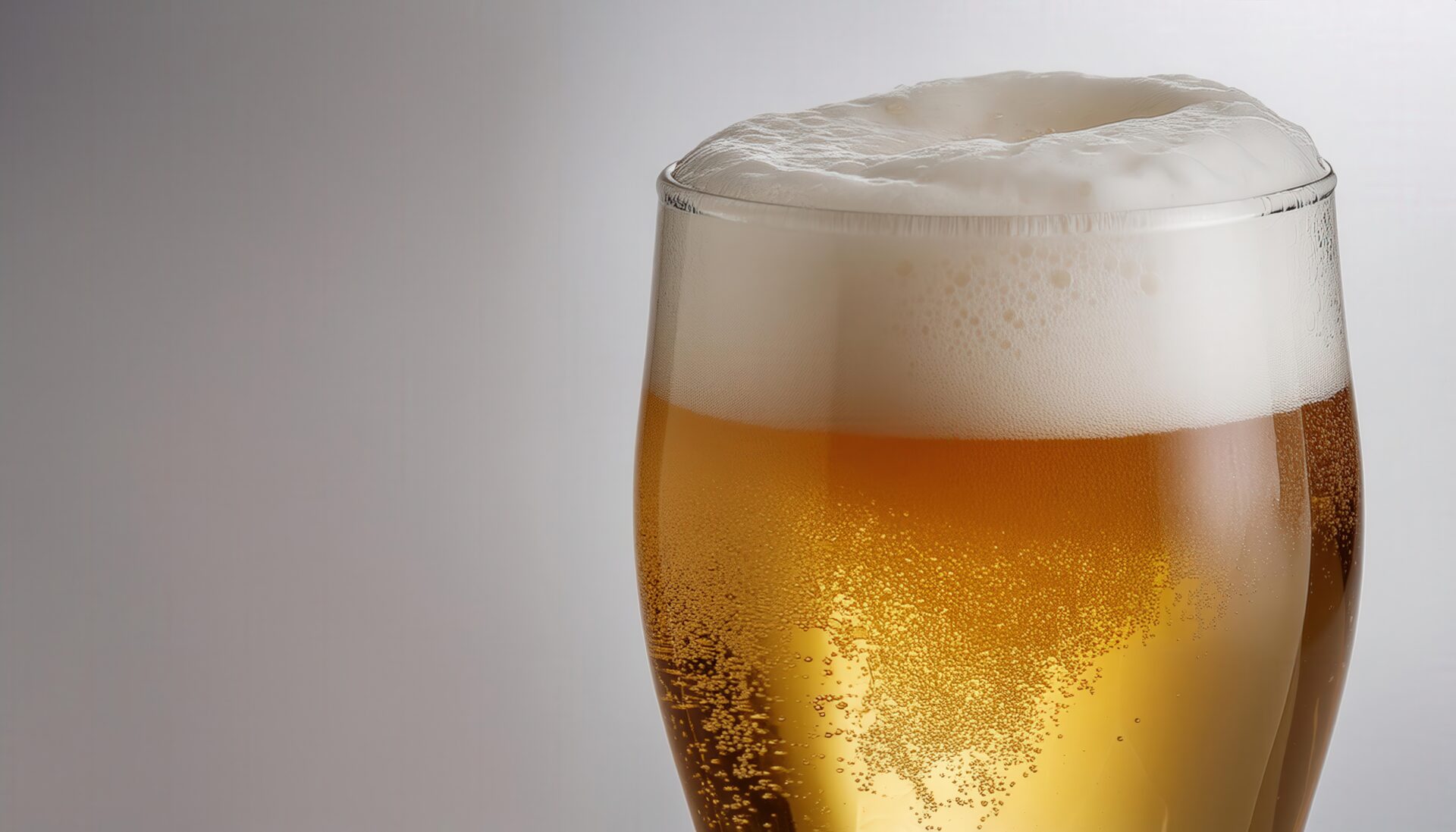 白背景で泡立つビールグラスの部分カット