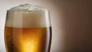 淡色背景で泡立つビールグラスのクローズアップ